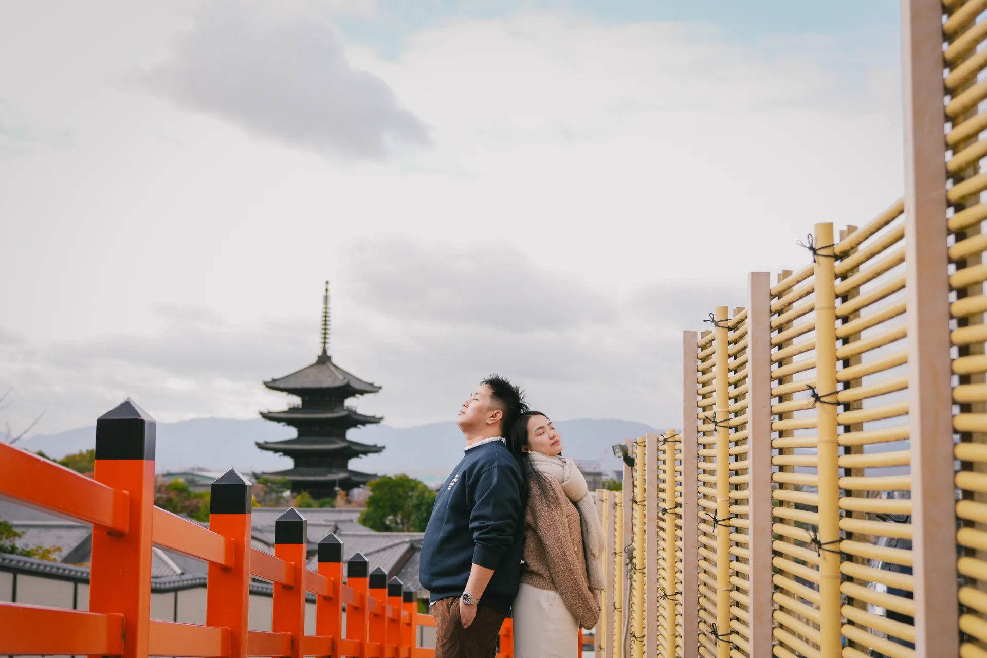 Rein and Mhae back to back on the vermillion bridge, Yasaka Pagoda on the skyline