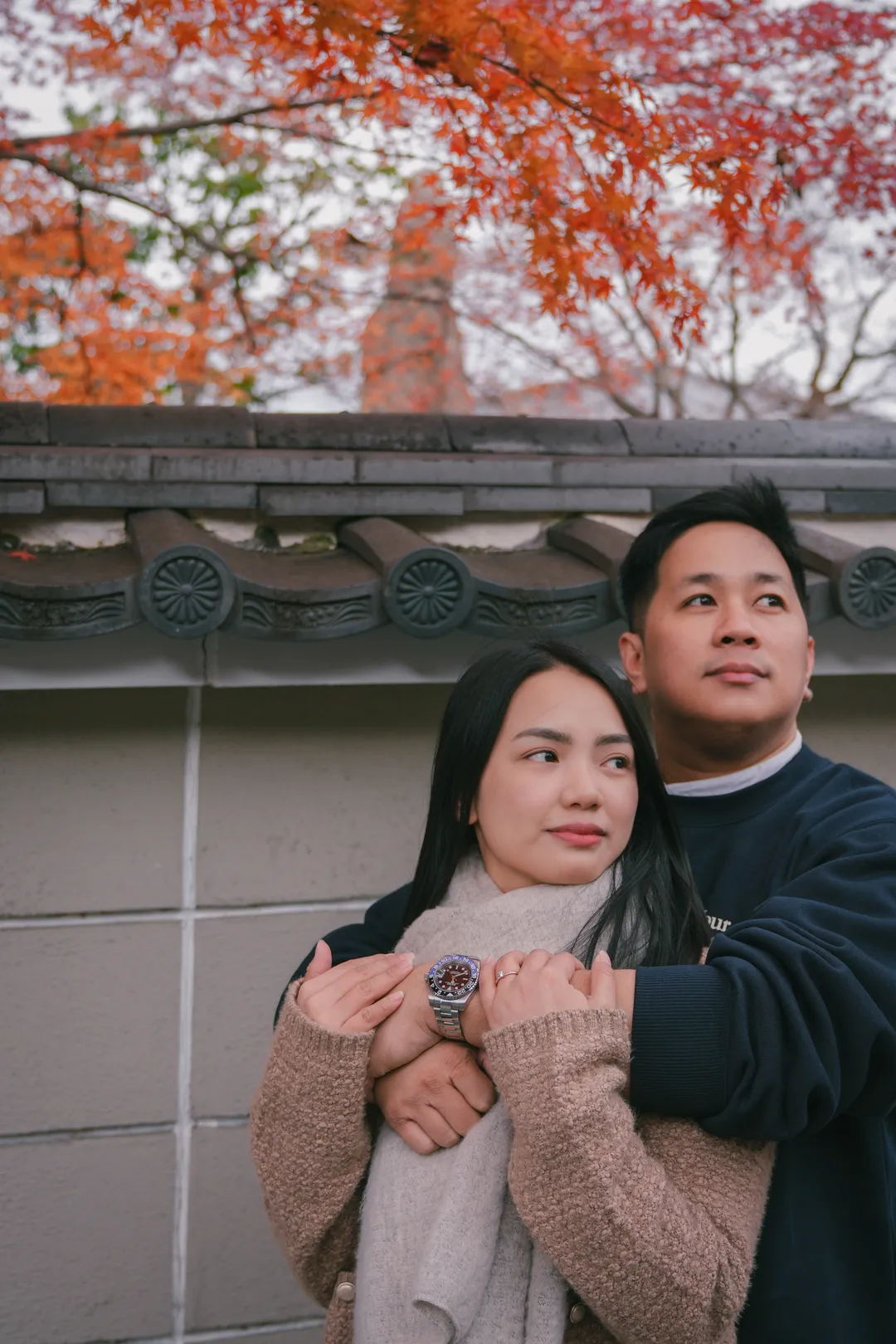 Holding each other under red maple leaves